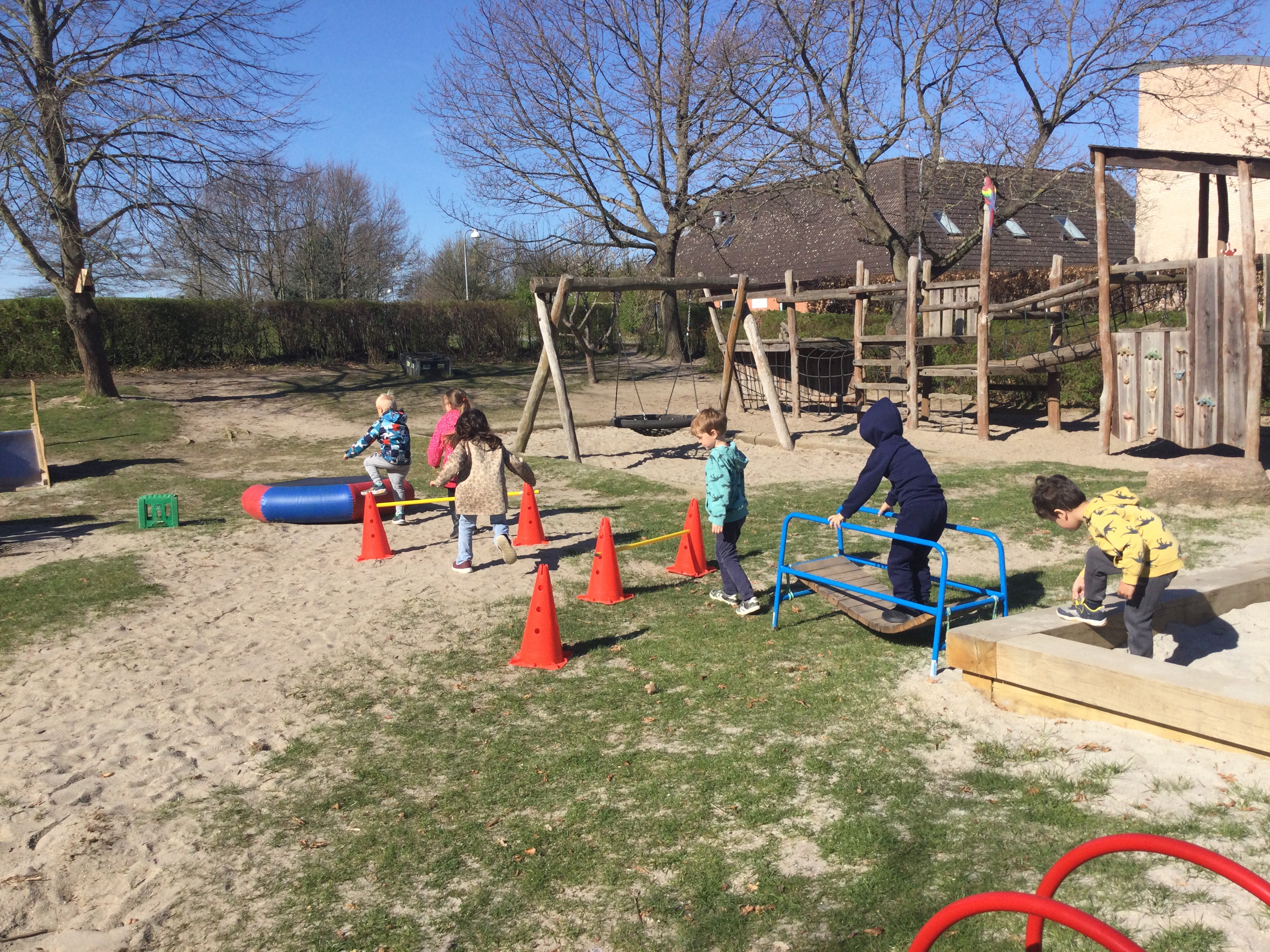 Børn balancerer på legepladsen